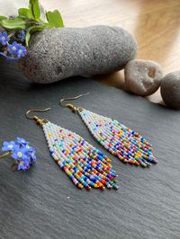 These confetti earrings are just so fun Brightly coloured and lightweight, these earrings embody the party spirit. Perfect to brighten any outfit, night or day!! Beautiful handmade gift for her Material: Miyuki and Czech seed beads handwoven using durable black thread. Technique: double brick stitch, fringing  Ear wire: You can choose between ear hooks, leverback or clip-on fittings. I offer a choice of finishes including sterling silver 925, gold-plated, golden and silver-colour fittings to suit most needs.   Dimensions: The length stated includes the handmade beaded piece and wire guard. For the drop length, add 1.2 - 1.6 cm (ear wire-dependent)  Packaging: Earrings are sent in a pretty, recyclable card envelop with a gold heart and colourful paper bow (see picture) Care instructions: St