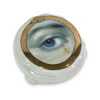 Our Ceramic Lover's Eye Box is a delightful fusion of artistry and timeless romance. Hand-decorated with intricate details (such as the gorgeous golden ouroboros), this ceramic box is a visual love story.Gilded in elegance, the box features a 24 Kt Gold Applique. The eye, a central motif, beckons with mystery and sentiment, capturing the essence of the Lover's Eye tradition.Designed by the creative minds at Spitfire Girl, this 5" diameter box and each stroke, each detail tells a tale of romance,