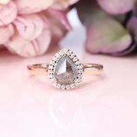 Meet Winter. Her elegance is truly breathtaking. Her unusual salt and pepper pear shaped, rose cut diamond takes centre stage, adorned with an amazing halo of beautiful white diamonds. Winter’s precious pear is cradled in a basket setting, effortlessly reaching up from the ring itself to allow light to showcase her mos