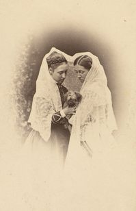 Three-quarters length photograph of Princess Louise and Miss Emily Cathcart standing facing each other, both looking down at the small dog, possibly a Yorkshire terrier, which they hold together. A lacy shawl has been placed around the head of both.  By: W & D Downey  Dated: May 1868 Source: The Royal Collection Trust  #QueenVictoria #PrincessVictoria #Queen #Princess #History #Historical #Interesting #HistoricalFact #VictorianAge #RoyalCollectionTrust #BritishRoyalFamily #RoyalFamily #RoyalBaby #PrinceAlbert #HistoricalPhotograph