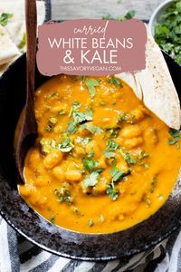 This Curried White Beans & Kale recipe is cozy and veggie packed! Beans are simmered in a coconut & squash sauce to make a delicious vegan curry!