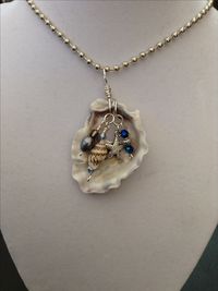 Seashell pendant with wire wrapped charms and pearls.