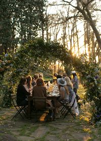 Magical dinner at sunset. Flower arches above tables for wedding.