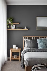 I like how this space is asymmetrical. I love the minimalist shelves and the colors of the bedding.