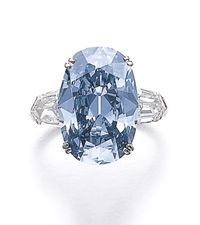 Deep blue diamond ring Set with an oval fancy deep blue diamond weighing 7.74 carats, between shield-shaped diamond shoulders.