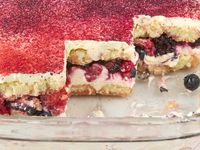 angled shot of the berry chantilly tiramisu in a baking dish with a few slices taken out of it.