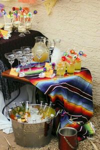 Fiesta beverage station with a serape tablecloth. Fiesta wedding inspiration.