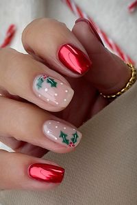 Short chrome red festive Christmas nails with two accent nude nails adorned with red and green holly nail art and white dots - Credit: Instagram@lindseysbeautylounge1