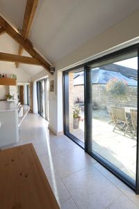 These slim aluminium #patiodoors fill the traditional barn door openings of this barn conversion. The slim aluminium frames allow the most glass possible, ensuring that the new kitchen is full of natural light.