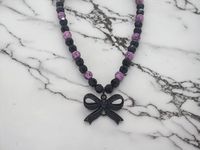 Bow Necklace - Black Bow Necklace - Pink and Black Necklace - Gothic Necklace - Pink and Black Necklace For Women - Bow Necklace For Women This necklace measures 17 1/2" in length.  This necklace is comprised of a black metal black jeweled bow pendant, pink acrylic beads with black swirls of color on them, and black acrylic multifaceted beads.  This necklace is strung on beading wire with a lobster clasp for closure.  So I found the black bow pendant and I fell in love with it.  The black jewels on it give it a great sparkle.  So to compliment the bow I used pink and black beads.  This necklace has a Gothic look.  This necklace is great for concerts and music events!