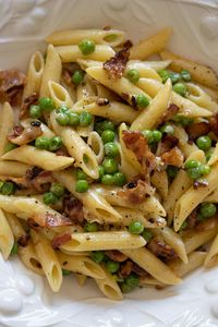 This quick, easy pasta dish takes as long as it takes to cook the pasta itself. It is a savory combination of sweet green peas with crisp onions and bacon. Last-minute dinner? This pasta recipe is your dish and soon will be your go-to dish as well.