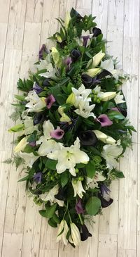 A gorgeous, elegant casket spray made up in white oriental lily with purple calla Lily’s with lush green foliage’s and berries.  Made by Signature Flowers, Bicester   #funeral #funeralflowers #casketspray #coffinspray #floraltribute #flowertribute #lily #callalily #orientallily #bicester