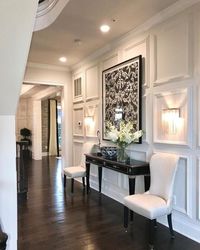 This hallway is symmetrical because both lights and chairs are at an equal position and are identical to the ones on the other side.