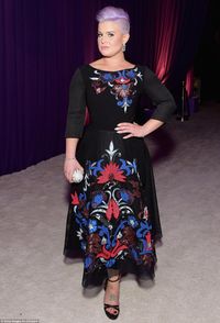 Ozzy's daughter: Kelly Osbourne had changed out of her all-black frock as she sported a black dress with red and blue embroidery and a purple mohawk hairstyle