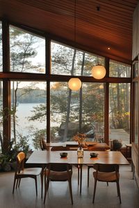 Mid century modern house interior with teak furniture and large windows overlooking a stunning lakeside. Discover how to transform your home with stylish Mid-Century Modern interior decor ideas that blend functionality with iconic design.