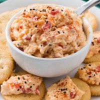 With ample seasonings and just a little kick, creamy Southern pimento cheese is great with everything from crackers or burgers to crab cakes or grits! This cheddar cheese spread also makes a great cold party appetizer dip that doesn't require the oven.