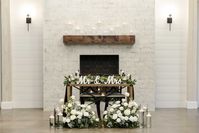 wood sweetheart table in front of white brick fireplace