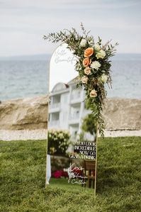 This is the most fun welcome mirror at this wedding reception. The wedding flowers are so beautiful and really take this installation to the next level.