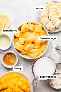 Mango, coconut milk, banan, honey, and lemon juice in separate bowls.