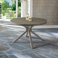 Our Bridgeport Trestle Round Dining Table features an artful, crisscross-styled base and a tabletop etched to resemble slatted wood. A powdercoat grey finish equips it for durable, outdoor living. Versatile for a variety of chair styles; perfect for dining al fresco.  Inspired by rustic farmhouse trestle table designs. 48" comfortably seats 4 6. 60" comfortably seats 6 8. Tabletop is etched to resemble real wood. Slatted surface prevents pooling water. Foot glides to protect floors. Finish may e