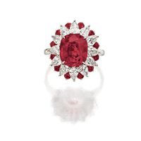 RUBY AND DIAMOND RING. Centring on an oval ruby weighing 5.03 carats, within a tiered border of pear-shaped diamonds and circular-cut rubies altogether weighing approximately 2.40 carats, mounted in platinum.