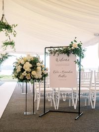 Welcome sign and aisle florals at the aisle entrance in Woodmark tent wedding.