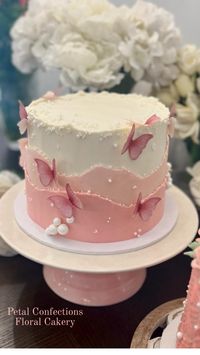 Pink buttercream layers in a fault-line style cake with delicate butterflies