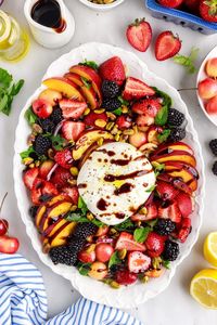 Peach Burrata Salad is full of refreshing flavors from the berries, cherries, fresh peaches, and creamy burrata cheese! The roasted pistachios give a nice little crunch and it's drizzled with a balsamic glaze and lemon olive oil.