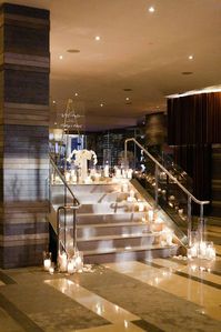 Four Seasons Seattle staircase lined with white hurricane candles and floral leading to a glam ballroom wedding | Flora Nova Design