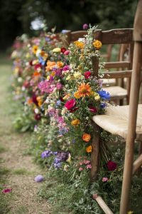 Colorful flowers adorning wooden chairs. Unleash your inner florist with wild and whimsical floral wedding ideas that will make your special day bloom like never before.