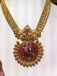 Gold ball necklace with gorgeous kemp ruby pendant. For inquiries please contact the seller below. Seller Name : Tirupati Jewellers Contact : 098488 90790 Related PostsGold Ruby Emerald Step NecklaceGold Antique Uncut Diamond NecklaceAntique Lakshmi Necklace SetBeaded Necklace with Antique Pendant160 Grams Gold Neclace With Krishna PendantGold Clustered Bead NecklaceGold Plated Silver Antique Necklace SetAntique …