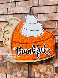 Our newest Thanksgiving door hanger is SWEET as PIE!  Our Thankful Pie door hanger is the perfect, large door hanger to make a statement on your front door this holiday season! This door hanger is complete with the intricate hand painted detailing, and gorgeous glittering accents in that truly pop! Choose from several wording options and wording style options to create the prefect, unique door hanger for your front door! >>All of our door hangers are hand designed/cut and made with a high quality 1/2 inch thick MDF wood. This wood will not warp or splinter with time or weather unlike other woods such as plywood. These are perfect for indoor/outdoor usage! Additionally, ALL of our door hangers are front/side paint only. You may find sporadic paint occasionally on the back due to the multi-s