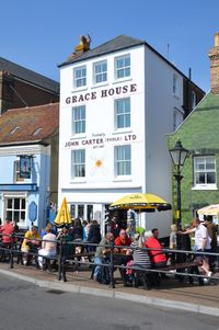 Our shop on Poole Quay, with members of the public sitting outside, catching the sun, soaking up the atmosphere and drinling wine and beer before building up the courage to enter Grace House with their purses and wallets more than half full!