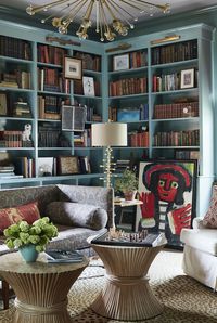 a room with a bookcase and a table with a chair and a couch