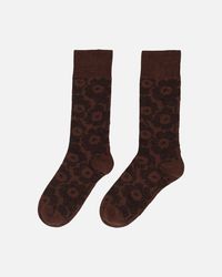 The Oras knitted wool socks feature the Unikko pattern.  This product includes 35% recycled wool and 24% recycled polyamide.  Unikko was created by Maija Isola in 1964 and has since become an international icon of print design. The founder of Marimekko, Armi Ratia, believed that it was not possible to faithfully capture the true essence of real flowers in print, which is why floral prints were earlier excluded from Marimekko collections. So, Maija Isola designed Unikko to be an abstraction of a flower rather than a photorealistic rendition. Today, Unikko is a powerful emblem of joy and creativity, seamlessly integrated into Marimekko´s design identity.