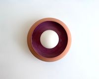 A round wall lamp in natural terracotta with a shiny pink glaze on the inside. Popping on every wall with warm material and rich and deep colors. Please note that this object is handmade, and each piece is unique. Technical: Dia: 7.8\10.2 inch.   20\26 CM Lamp holder: G9  Wall rose (white) : 10 cm  /  4 inches The bulb is not included