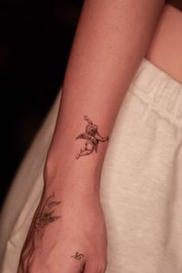 Fine line cherub tattoo