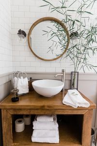 Home Away From Home: New Albany Natives Restore a 1938 Craftsman - Mud and Magnolias - subway tile bathroom, modern farmhouse bathrooms, retreat bathroom, bathroom renovation, wood in bathroom, round bathroom mirror, modern bath lighting