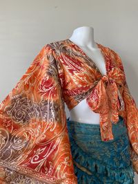 This 70s inspired blouse is vibrant and eye catching - our orange ombré print top is speckled with gold print that sparkle with movement.  Front tie crop top with long bouncy butterfly sleeves. Flowy whimsical design that creates soft movement while walking. Feminine design that makes you feel gorgeous and pretty.  Each design is unique with it's own style and colors.  One size Fits XS - M can also fit Large  Please note this top is crop top! Easy to wear and you'll always look the great! Multip