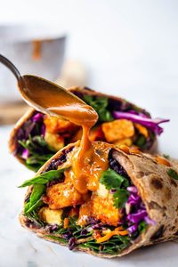 Delicious Thai Burritos with Peanut Sauce, avocado, rice, peanut tofu, black beans, herbs and veggies. Vegan, flavorful and plant-based.