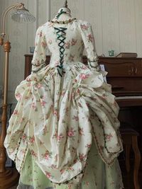 Immerse yourself in the opulent elegance of the Rococo era with our stunning Marie Antoinette-inspired ball gown. This exquisite dress, featuring a pastel green skirt and a pink floral bodice, seamlessly blends historical charm with modern sophistication, making it the perfect choice for a fairy-tale wedding. Rococo Style Elegance: This gown showcases the intricate detailing of Rococo fashion, with a structured bodice adorned with delicate lace and floral embroidery. Luxurious Craftsmanship: The