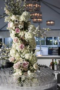 Tall white and pink column floral arrangement in the center of the bar. Dense flowers in a striking shape make a statement bar arrangement.