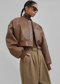 Color: Brown Grained faux leather fabric Relaxed fit Cropped profile Baseball collar Padded shoulders Single welt breast pocket with zip closure Front welt pockets Slightly elasticated ribbed trim Front zip closure Lined 100% Polyurethane Dry Clean By The Frankie Shop. Imported