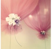 Tulle wrapped over balloons tied with ribbon and flowers.