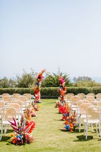 vibrant wedding ceremony floral towers and aisle arrangements full of tinted grasses and fresh flowers