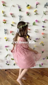 DIY Flower Wall 🌸 Save this post so you can make your own!  Supplies needed:  Faux flowers (I bought most of mine during a 50% off sale at @michaelsstores) Wire cutters Fishing line Floral tape (optional) Command hooks, tape, thumbtacks, nails, and/or dowel rod for hanging  🌸Separate flowers using wire cutters and arrange them in rows in the order you like. I liked seeing the layout on the floor before committing.  🌸Cut a long strand of fishing line and start tying flowers to the line. I tied my knots toward the tops of each flower, leaving a little space between each flower.  🌸Hang each strand, working from the middle row out, to keep everything centered. I used tape because it was most convenient for us. But command hooks, thumbtacks, or nails would be more secure. You could also att