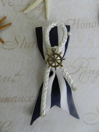 "Simply unique! Navy Blue/White Ribbon Boutonniere. A nautical rope has a Ship Wheel or Anchor in the center. This Boutonniere will be perfect for the Groomsmen in your bridal party. Item ships via Priority Flat Rate Box. Boutonniere measure Aprox. 4.\" long by 1.5\" wide. Please specify Charm - Anchor or Wheel in Bright Gold, Antique Brass or Silver. Charm style may vary slightly based on availability at time of order. INTERNATIONAL orders welcomed! Please convo us for proper shipping cost to y