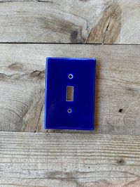 **This listings is for the solid royal blue light switch cover  NOTE:THESE ARE HAND PAINTED, SLIGHT VARIATIONS IN COLORS WILL OCCUR THESE PLATES ARE ONLY PAINTED ON THE SURFACE OF THE PLATE, NOT THE EDGES These  light switch plate covers add a little touch of functional art to your home decor, hand painted using a variety of ceramic, lead-free, glazes. These are made in Tucson, Arizona. You can choose this design in over 20 standard and hard to find combination configurations. Fired in a kiln at