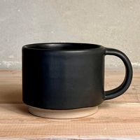 Elevate your daily coffee or tea ritual with this stylish black ceramic mug. Handcrafted with care, this mug features a smooth matte black finish that exudes sophistication and modern charm. The mug's minimalist design is complemented by a contrasting unglazed natural clay base, adding a touch of rustic elegance to its contemporary appearance. Perfect for both hot and cold beverages, this versatile mug is an excellent addition to your kitchenware collection or a thoughtful gift for coffee and tea lovers. Its timeless design fits seamlessly into any home decor style, making it a must-have for your daily enjoyment. Add this beautiful black ceramic mug to your cart today and enjoy a blend of modern aesthetics and functional design in every sip! DIMENSIONS Ø diameter 8 cm / 3.2" height 6 cm /