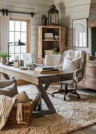 A modern farmhouse home office with shiplap walls, a large wooden desk, cozy textiles, and rustic decor. This space combines modern elements with farmhouse warmth.